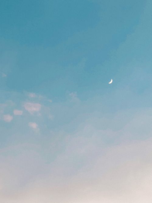 Free A serene sky with a crescent moon creating a peaceful atmosphere during twilight. Stock Photo