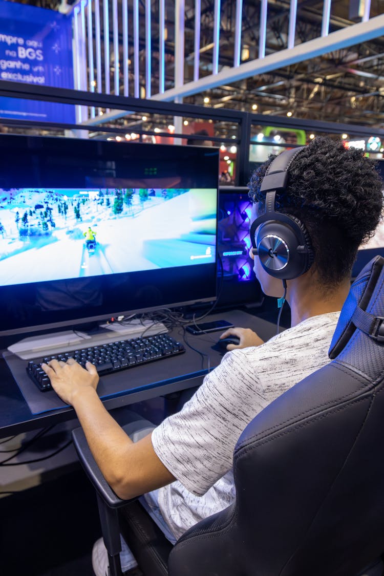 Boy Playing A Computer Game On Professional Equipment 