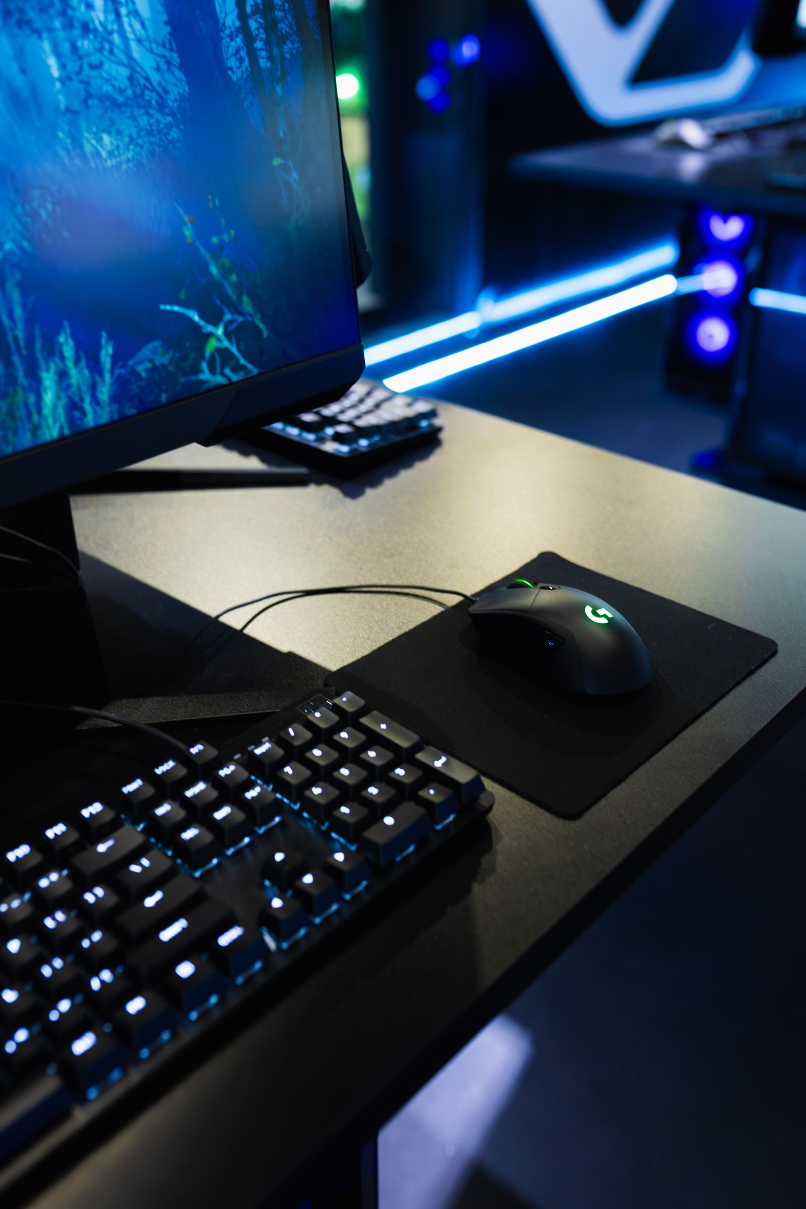 Modern gaming station with illuminated monitor, keyboard, mouse and desktop computer