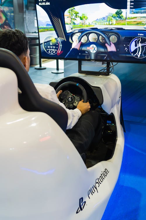 Gamer Sitting in a PlayStation Racing Simulator with a Logitech Racing Wheel