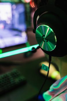 Engaging gaming session with pro headset in dynamic lighting environment.