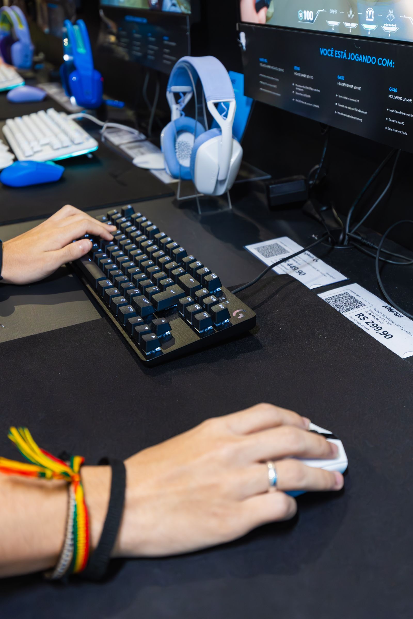 Gamer using a mechanical keyboard and gaming mouse at a multi-monitor station