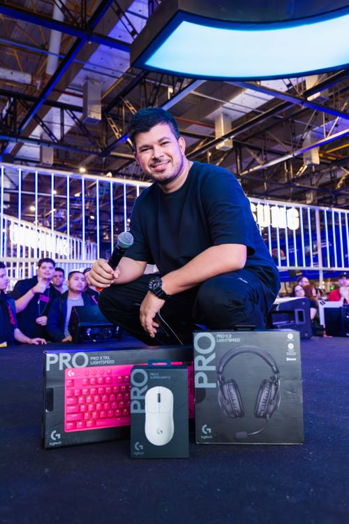 Man With Computer Microphone Man with a Microphone Next to Boxes with Logitech Gaming Peripherals at ...