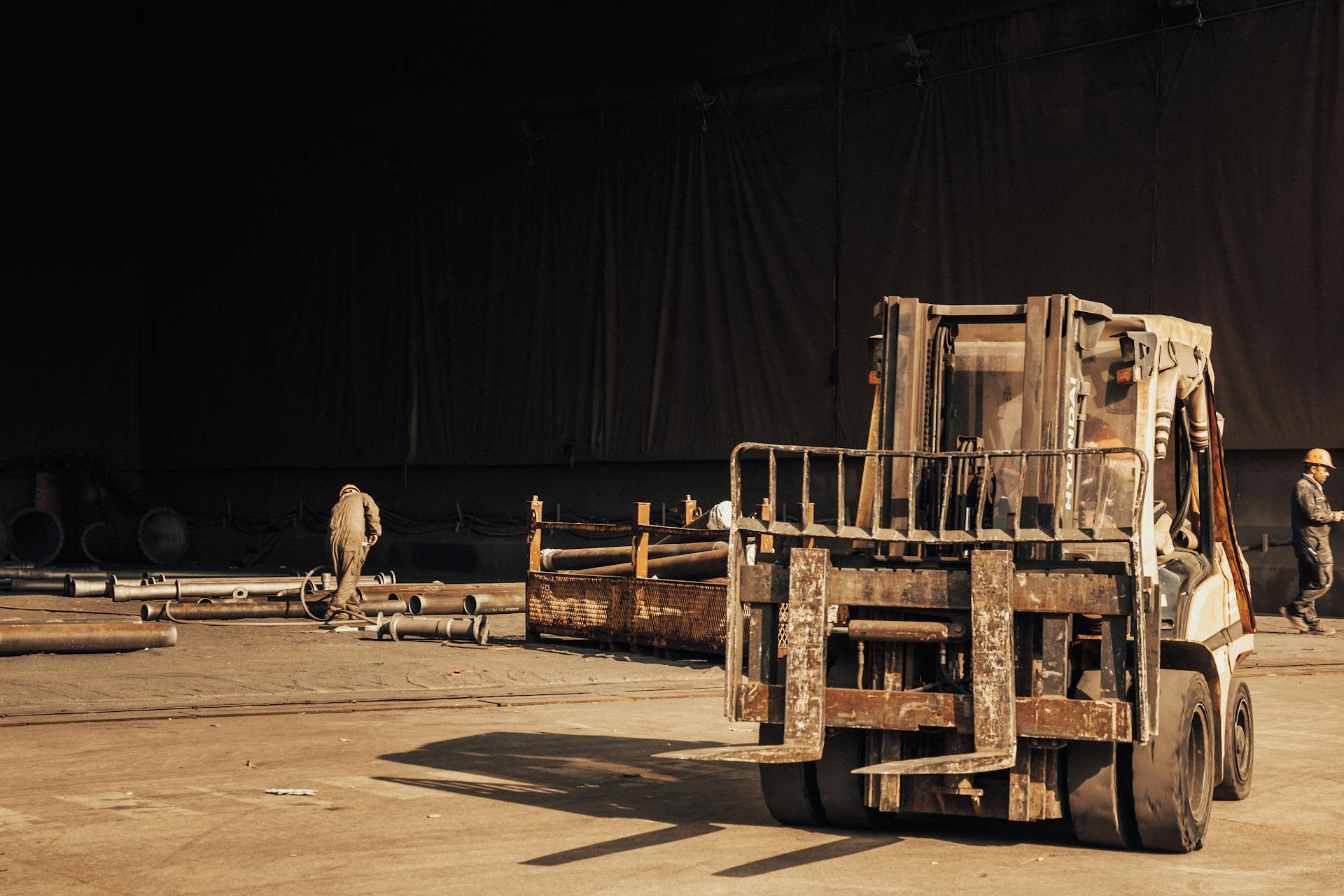 Industrial scene in Istanbul with workers and a forklift inside a warehouse.