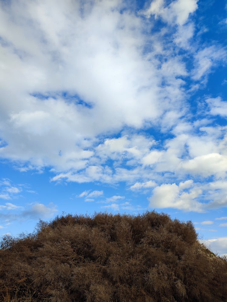 Clouds In The Blue Sky Above A Hill