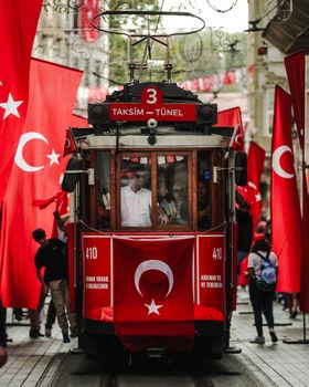 Historic tram in Istiklal Street adorned with Turkish flags in Istanbul.