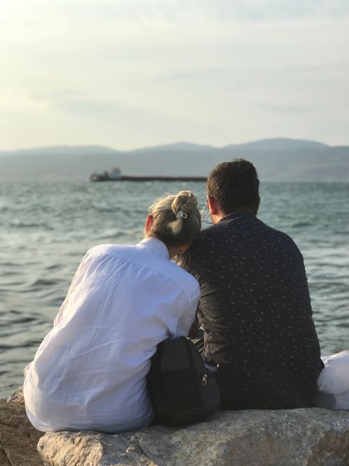 Free A couple sitting by the sea in İzmir, Türkiye, enjoying a serene vacation moment. Stock Photo