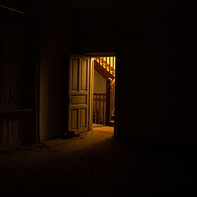 Porta aberta revelando uma escada iluminada