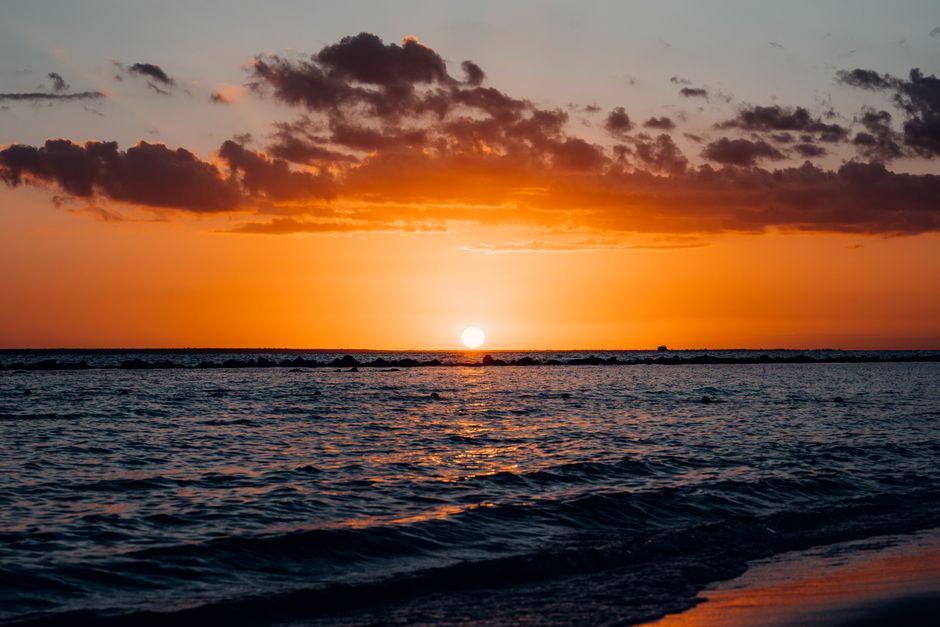 Captivating sunset view over the ocean in Santo Domingo, showcasing vibrant colors and serene waves.
