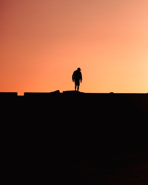 Silhouette of Person Standing Alone at Dusk