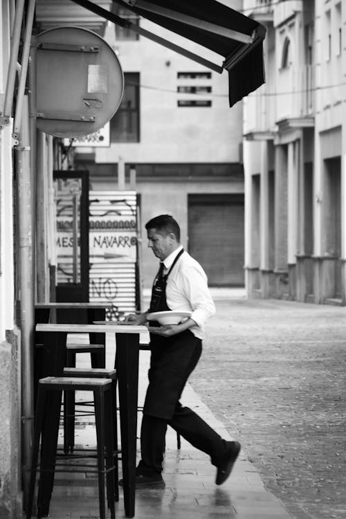 Waiter Cleaning Tables on Sidewalk