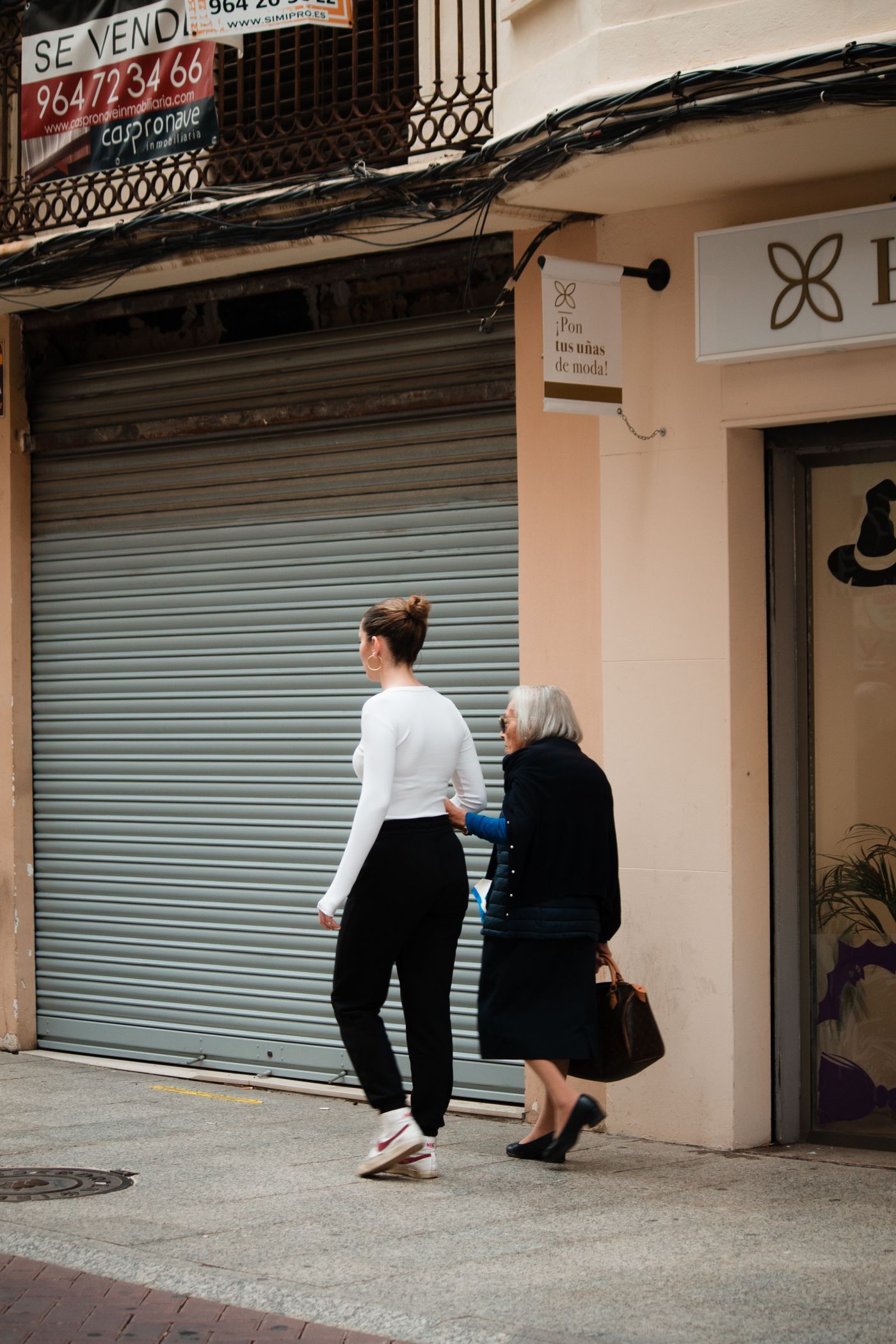 Acompañamiento de una mujer mayor por otra mujer en Valencia, España