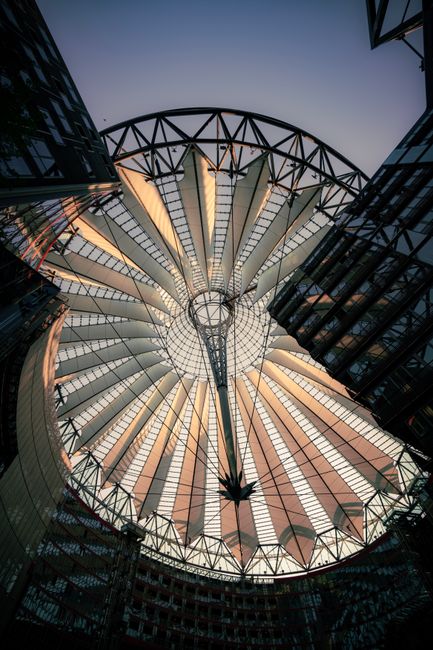 Low angle view of Sony Center's architectural canopy in Berlin at sunset.