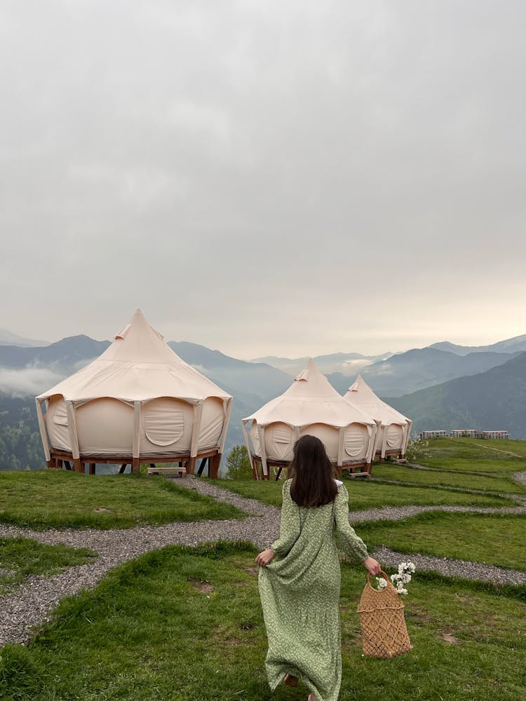 Woman Wearing A Green Dress And A Camp In Mountains