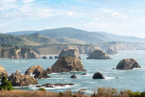 Free A breathtaking view of rocky coastal formations and ocean waves in a serene landscape. Stock Photo