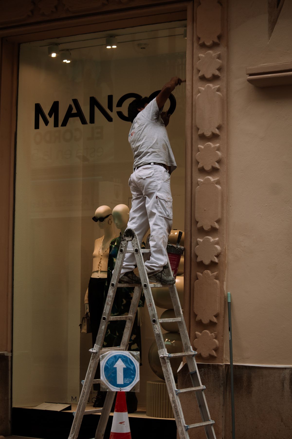 Profesional trabajando en la reforma de la fachada de un establecimiento comercial