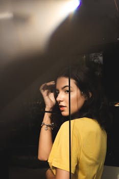 一位身着黄色衬衫的优雅女性肖像，光影效果美丽而富有戏剧性