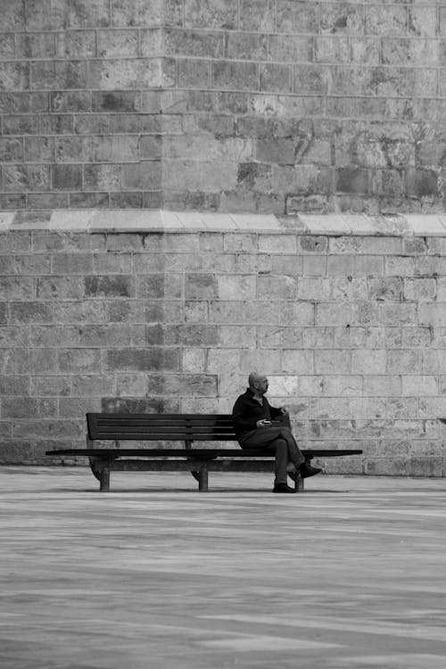 Man Sitting Alone on Wooden Bench