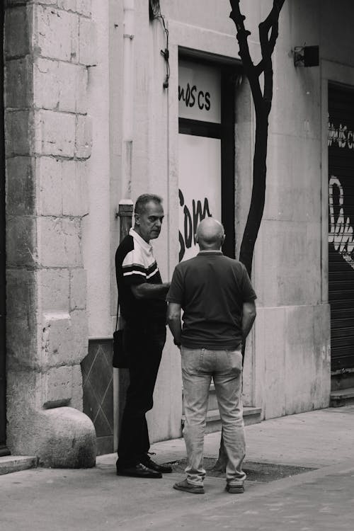 Two Men Standing on the Sidewalk and Talking 