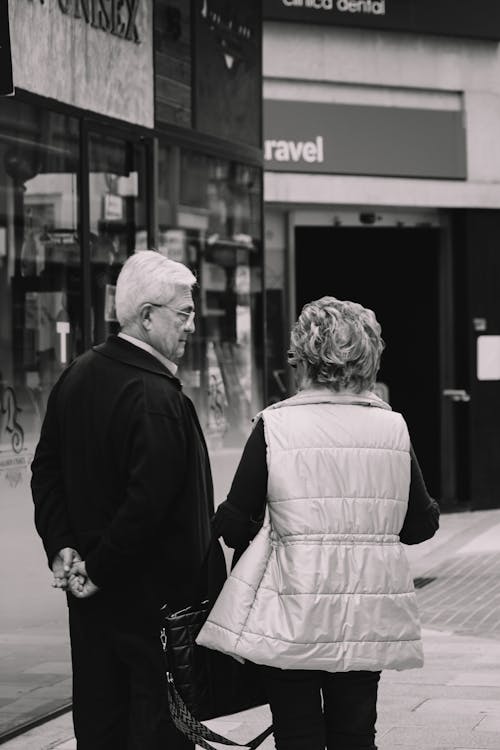 Back View of an Elderly Man and Woman Standing on the Sidewalk 