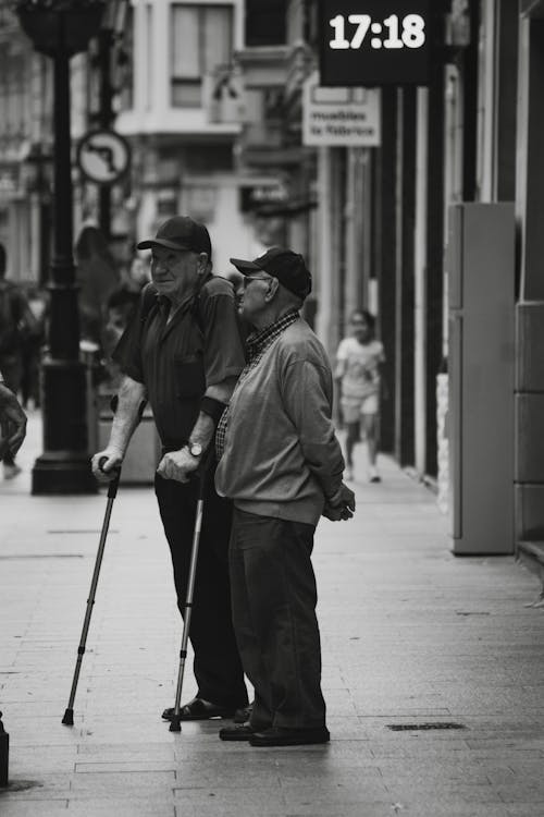 Elderly Men Standing on the Sidewalk in City 