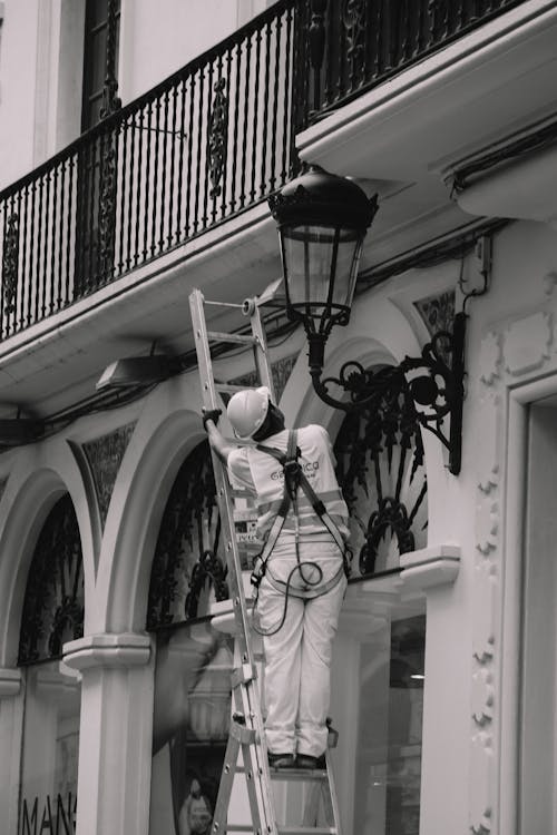 Worker on Ladder Looking at Lantern
