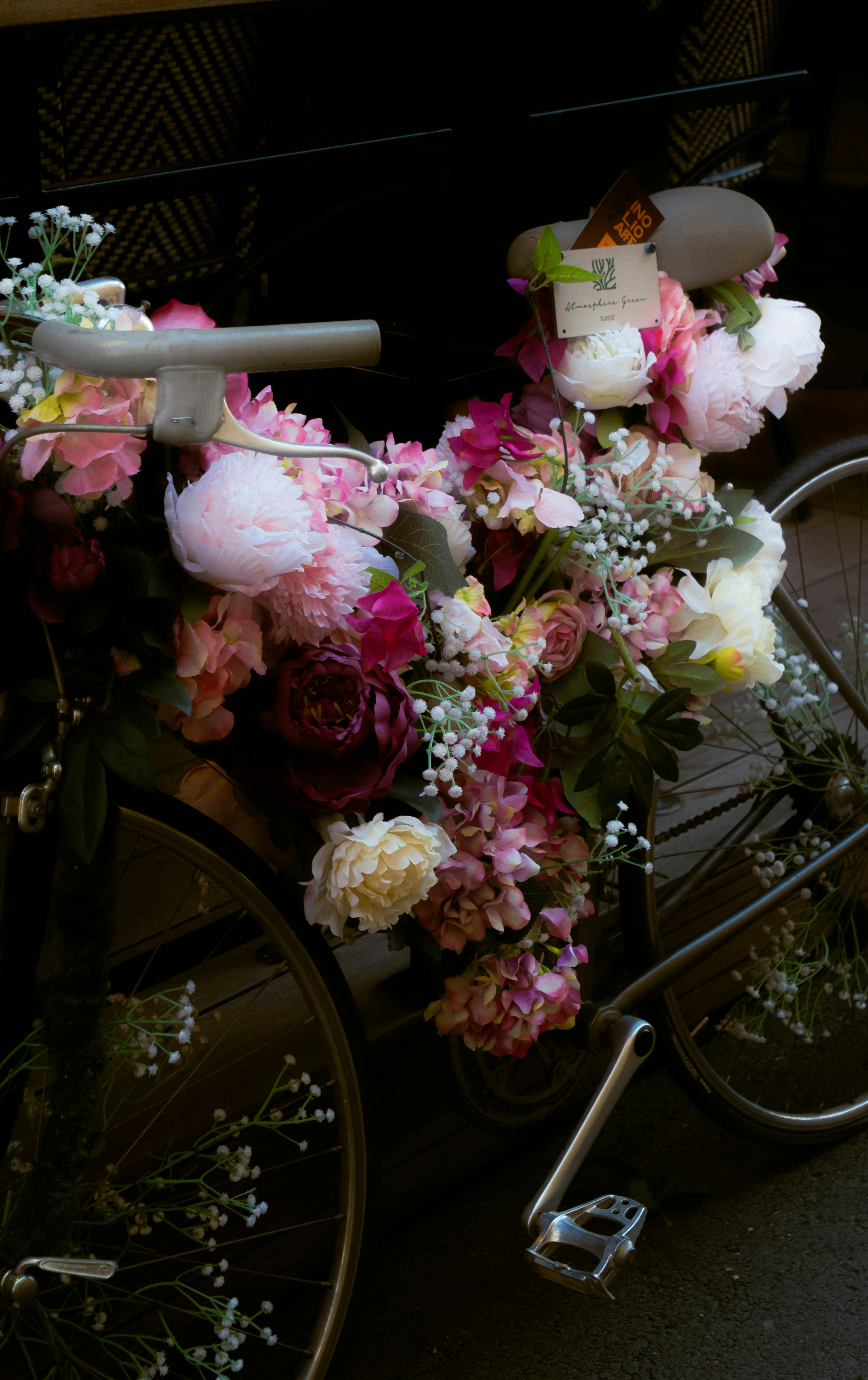A bicycle adorned with vibrant flowers and lush greenery, creating an artistic and colorful scene.