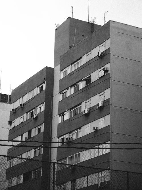 Free Black and white view of a modern apartment building facade in an urban setting. Stock Photo