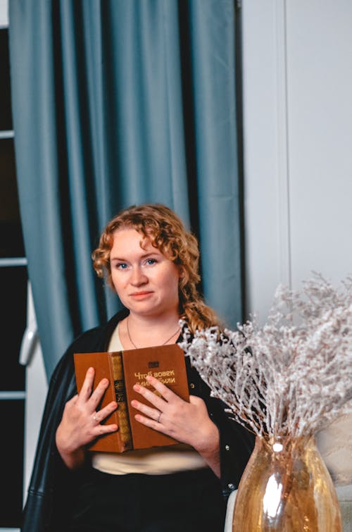 Woman Sitting and Holding a Book 