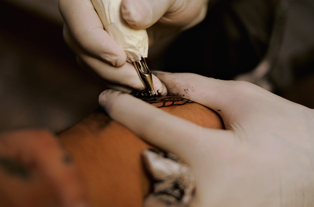 A close view of a hand tool placing pigment into skin