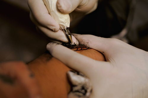 Free A tattoo artist skillfully inks a female client in a São Paulo studio. Stock Photo