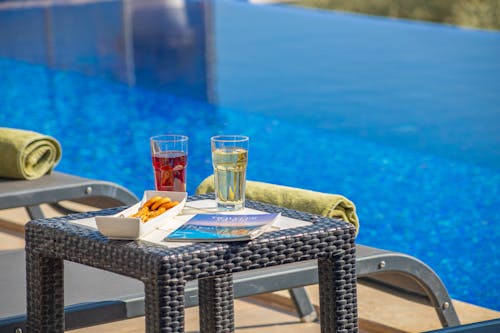 Drinks and a Snack on the Table by the Swimming Pool 