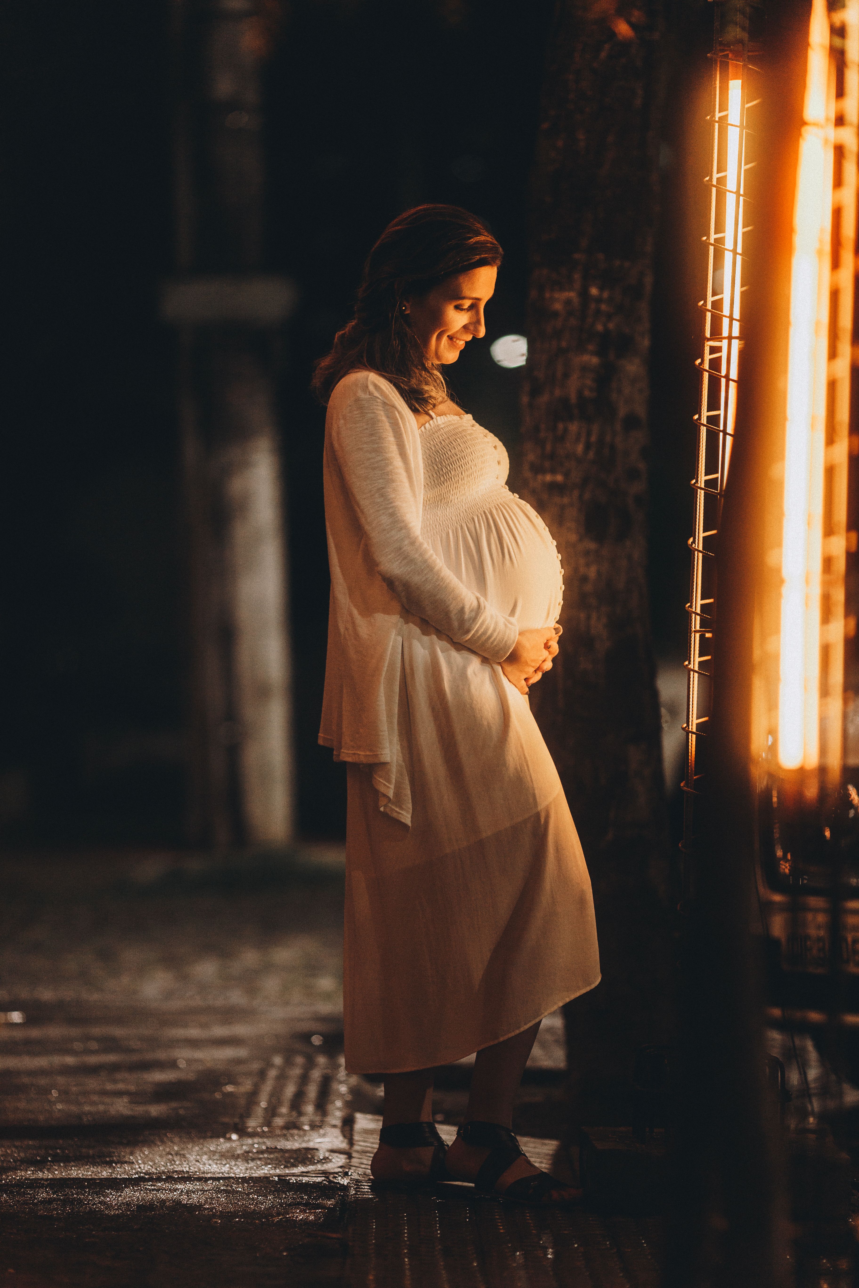 Pregnant Woman in a Dress Holding Her Stomach and Smiling · Free Stock ...