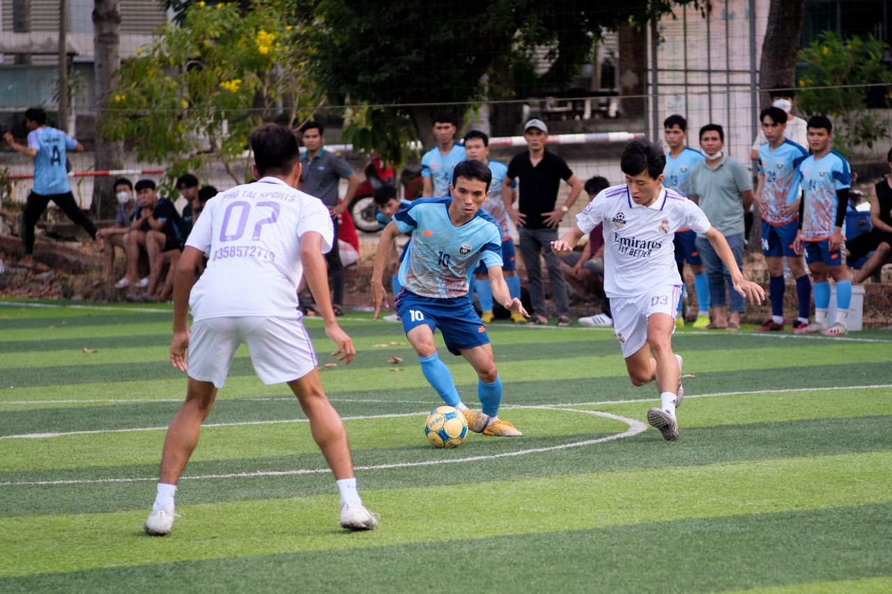 players energetically compete in a local soccer match while spectators
