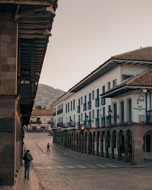 Free Scenic view of historic Cuzco street with colonial architecture and distant mountains at dusk. Stock Photo