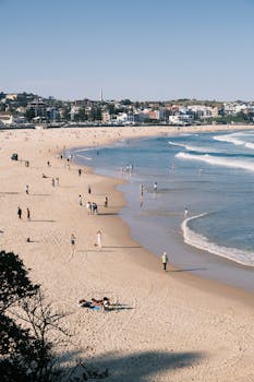 Enjoy the serene vistas of Bondi Beach during a sunny summer day with gentle waves and sandy shores.