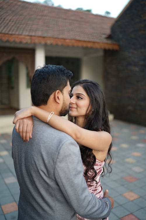 A Couple Embracing in Front of a House