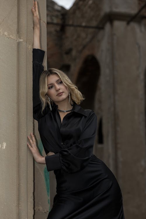 Woman in a Black Dress Leaning on a Wall 