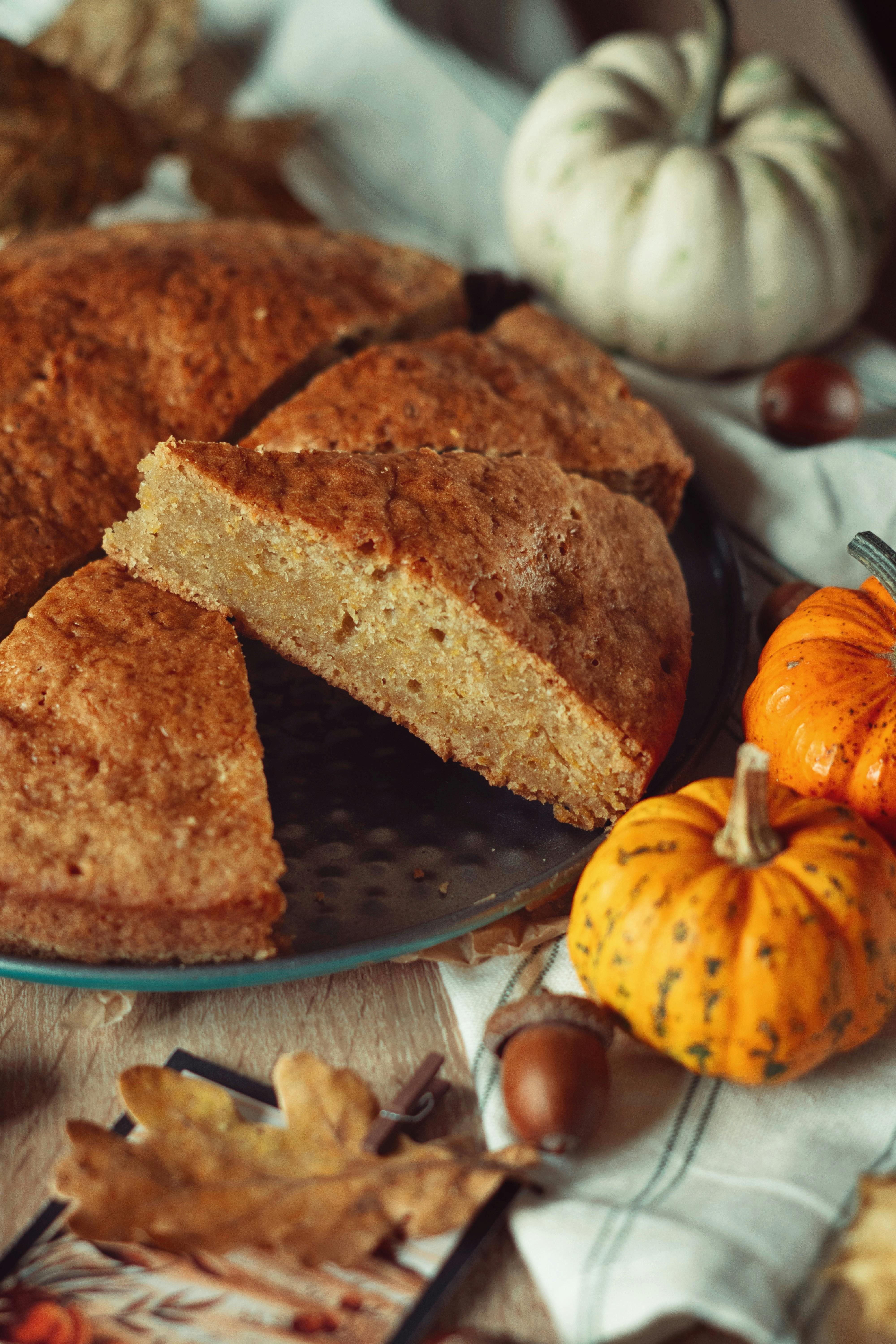 Sliced pumpkin cake with decorative gourds, perfect for fall celebrations.
