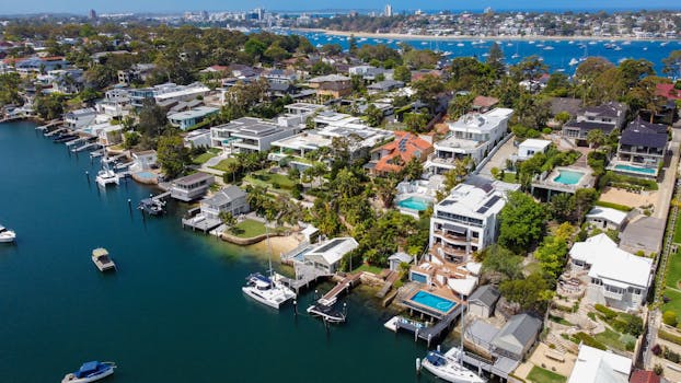 Stunning aerial view of Burraneer Bay, displaying luxury homes along the coastline in summer.