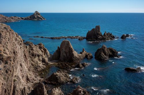 Free Explore the stunning rock formations along the Almeria coast, set against a vibrant blue ocean. Stock Photo