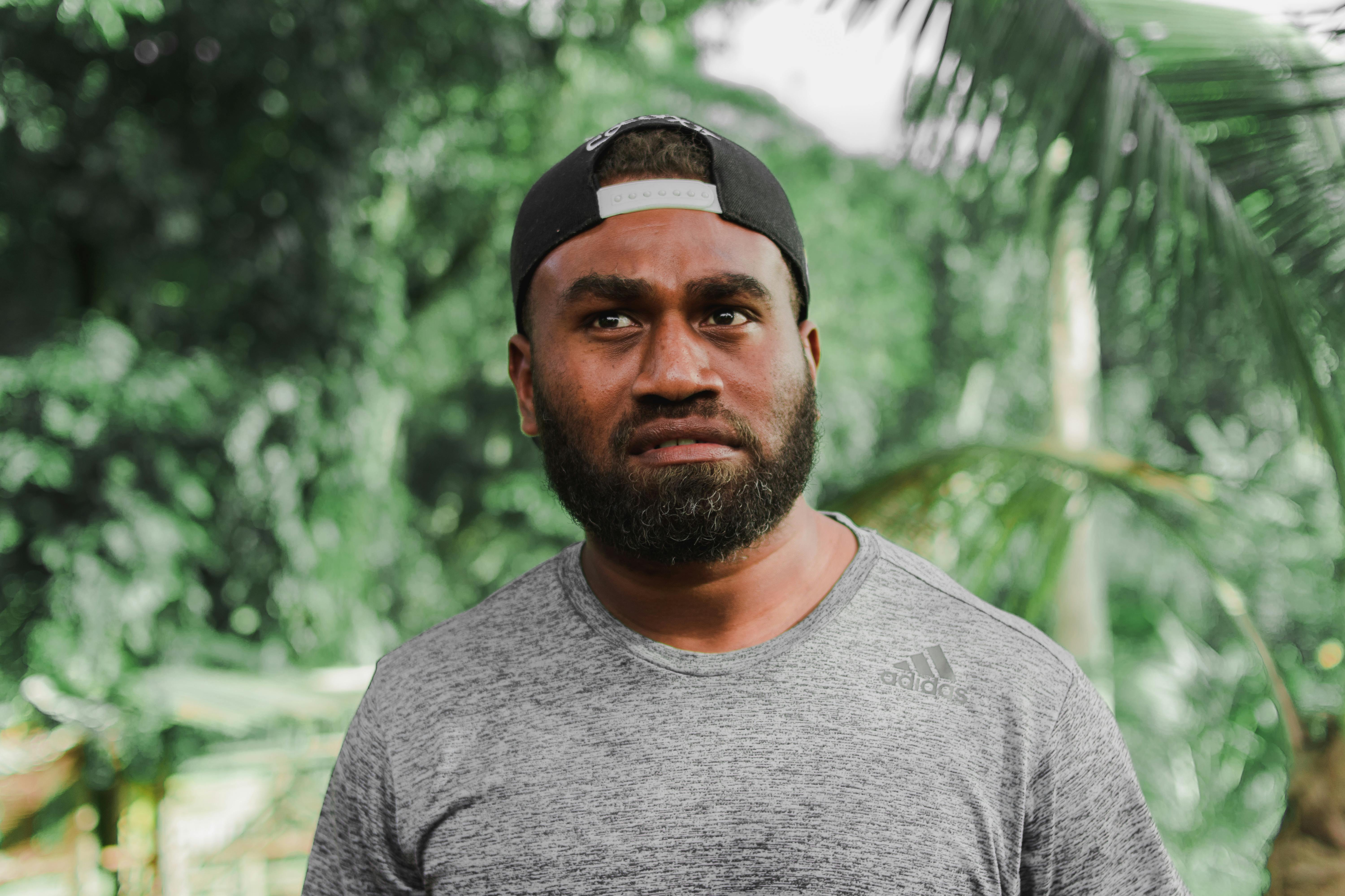 man wearing cap and adidas shirt