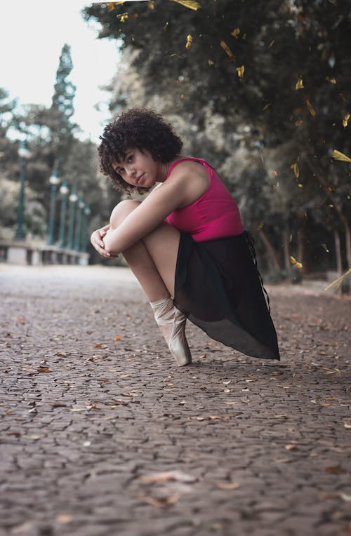 Zittende Ballerina Naast Groene En Bruine Bomen