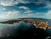 Stunning aerial view of a coastal town with marinas and yachts in a tropical island setting.