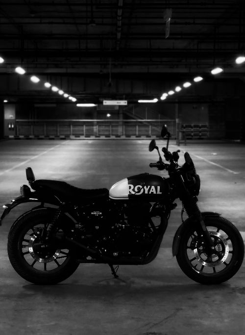 Free A stylish black and white motorcycle parked in an underground parking garage. Stock Photo
