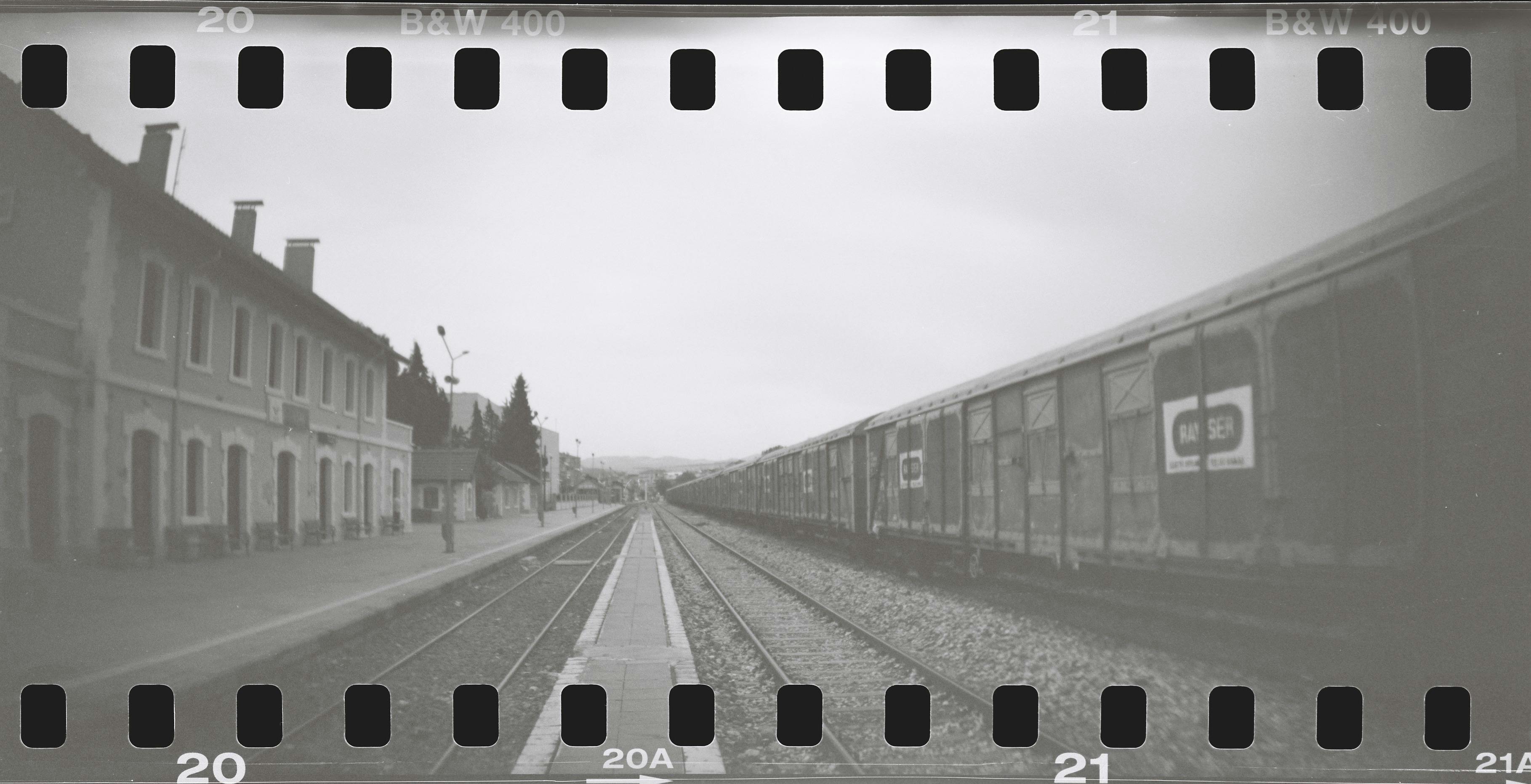 Retro black and white image of a train at a deserted railway station.