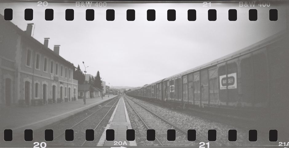 Retro black and white image of a train at a deserted railway station.