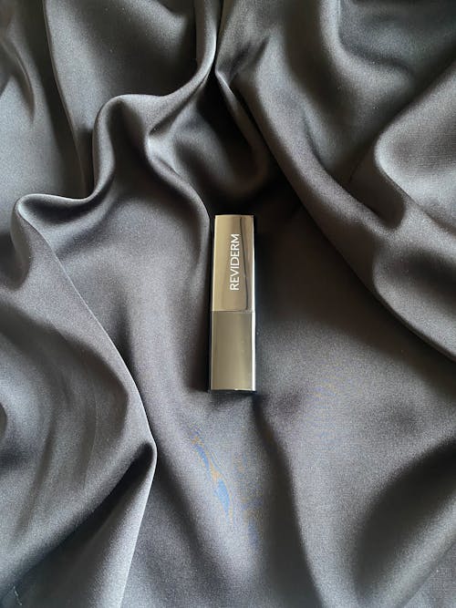 A Lipstick Lying on a Satin Fabric 