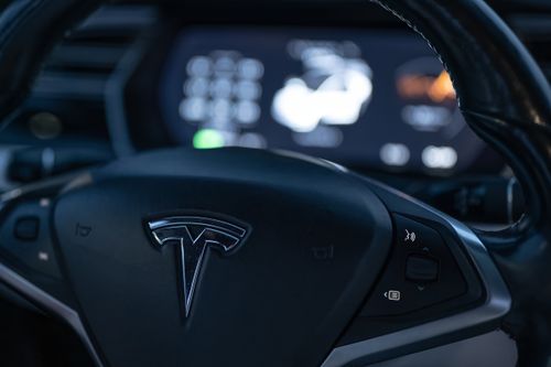 Free Detailed view of a Tesla steering wheel with dashboard display in focus, showcasing modern car interior design. Stock Photo