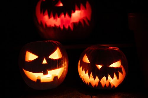 Free Three glowing jack-o'-lanterns at night, creating a spooky Halloween atmosphere. Stock Photo